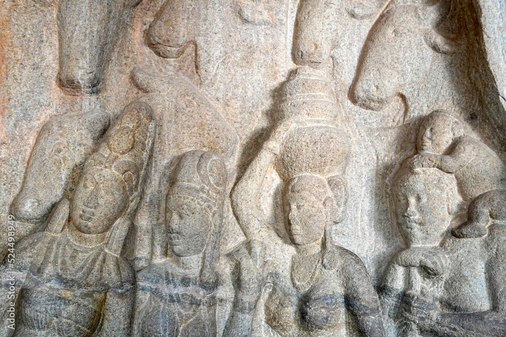 Human rock relief sculptures carved in the rock cut ancient cave temple in Mahabalipuram, Tamilnadu. Indian rock art of bas relief human sculptures at rock cut historical monolithic cave in Tamilnadu.