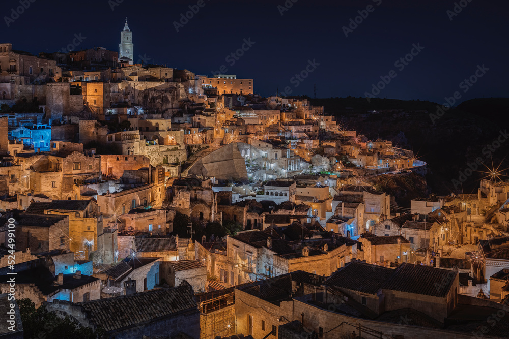 Matera by night, photos from the panoramic terrace. Photo from June 2022. You can see the basilica overlooking the town and the characteristic houses carved into the rock. Matera was the European capi