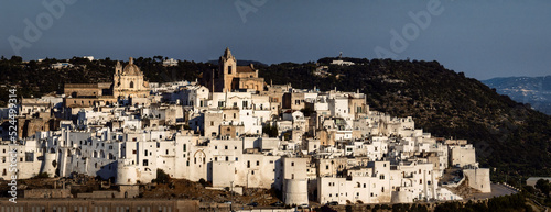 Overview of Ostuni (BR), the white city perched on the hill, with the typical white houses. Aerial photo with the drone of June 2022 photo taken at dawn.