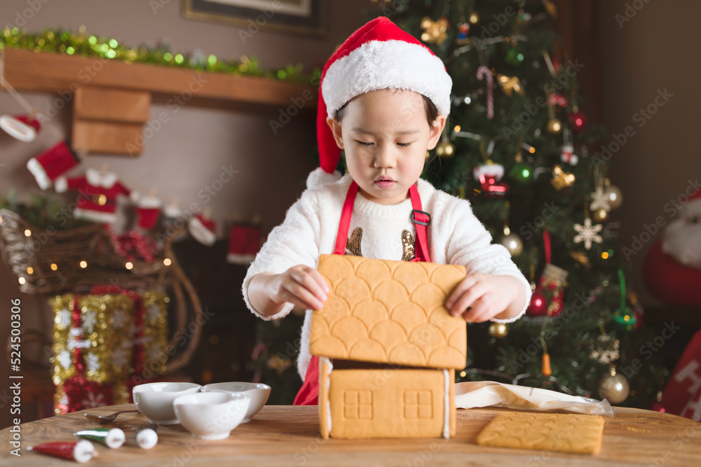 young girl making gingerbread house at home young girl making gingerbread house at home
