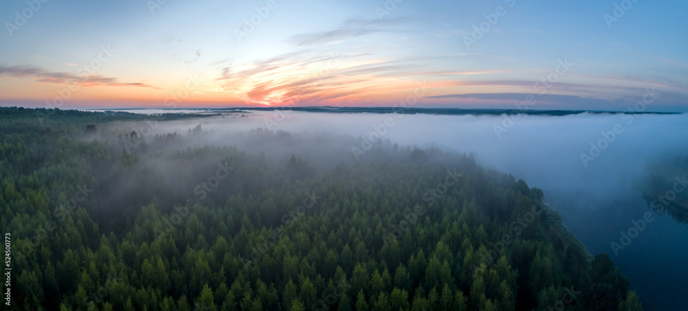 Summer dawn over foggy forest and river aerial drone view. Aerial panoramic landscape with sunset over the river and beautiful clouds on the sky.