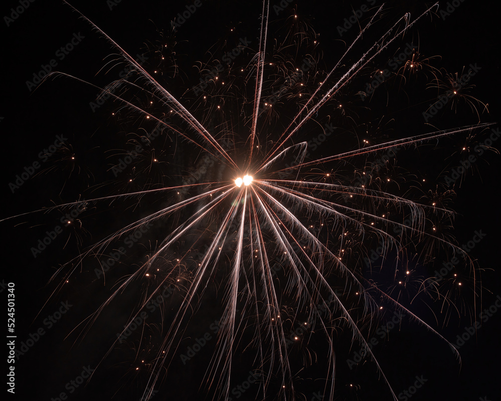 Flare from fireworks with rays of orange light from the centre and a lot of sparks on a black background Flare from fireworks with rays of orange light from the centre and a lot of sparks on a black background
