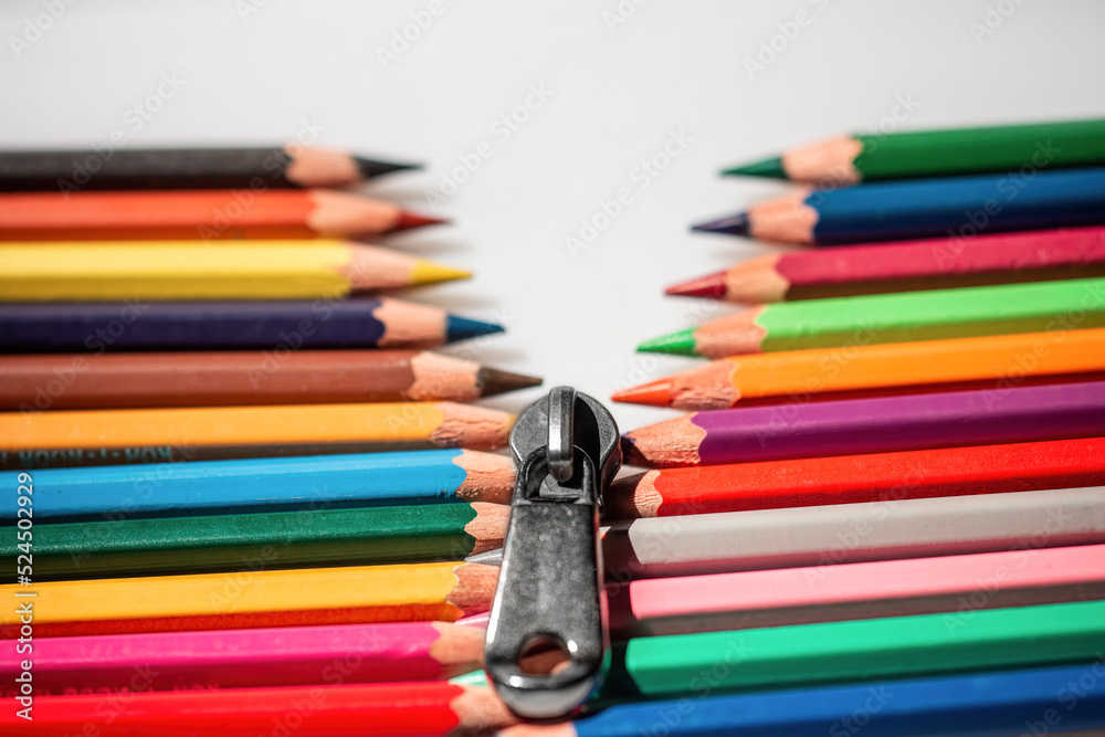 Fototapeta premium Two rows of multi-colored pencils imitating a zipper that diverge