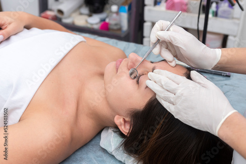 young woman lying on a table in an aesthetic center that performs beauty and facial aesthetic treatments with dermapen and dermaplaning techniques and eyelash service