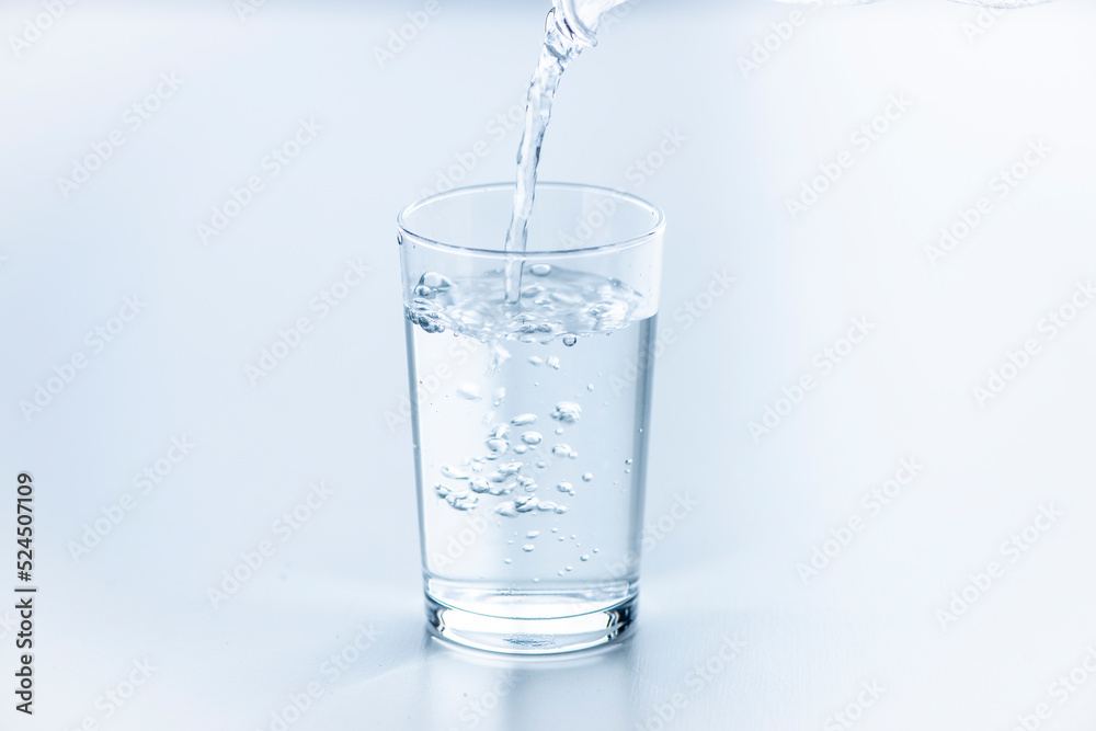 テーブルに置いたコップに水を注ぐ
テーブルに置いたコップに水を注ぐ