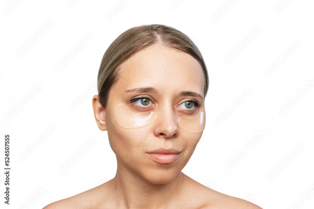 Portrait of a young caucasian woman with gel colorless transparent patches on the skin under her eyes isolated on a white background. Skin care, cosmetology concept Portrait of a young caucasian woman with gel colorless transparent patches on the skin under her eyes isolated on a white background. Skin care, cosmetology concept
