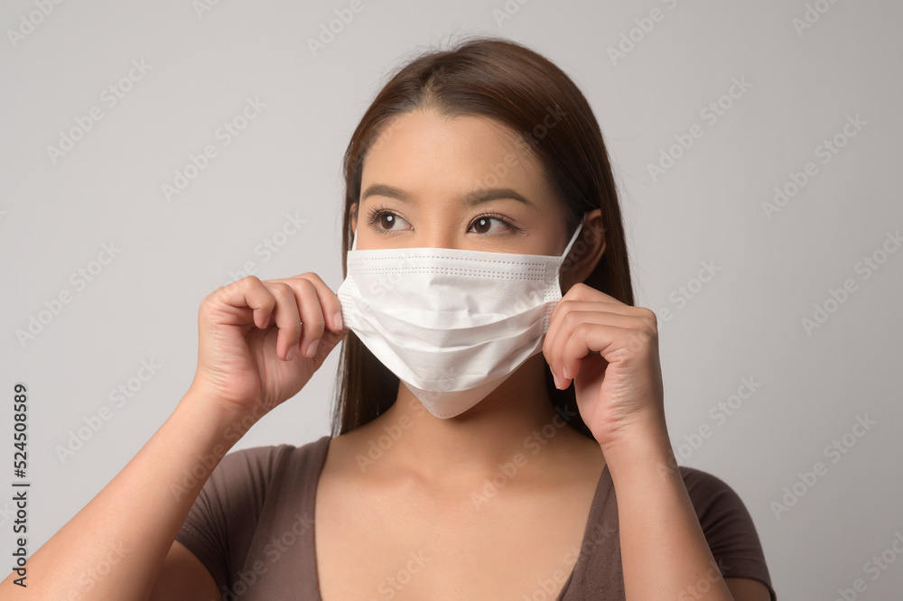 Young asian woman wearing protective mask over white background studio, safety travel , new normal , social distancing , covid19 and pandemic concept. Young asian woman wearing protective mask over white background studio, safety travel , new normal , social distancing , covid19 and pandemic concept.