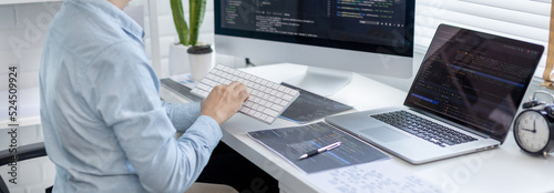 Professional development programmers are sit on a desk with work equipment such as: computer-laptop-tablet. for working in programming or writing code on  website,  HTML, javascript, Software.