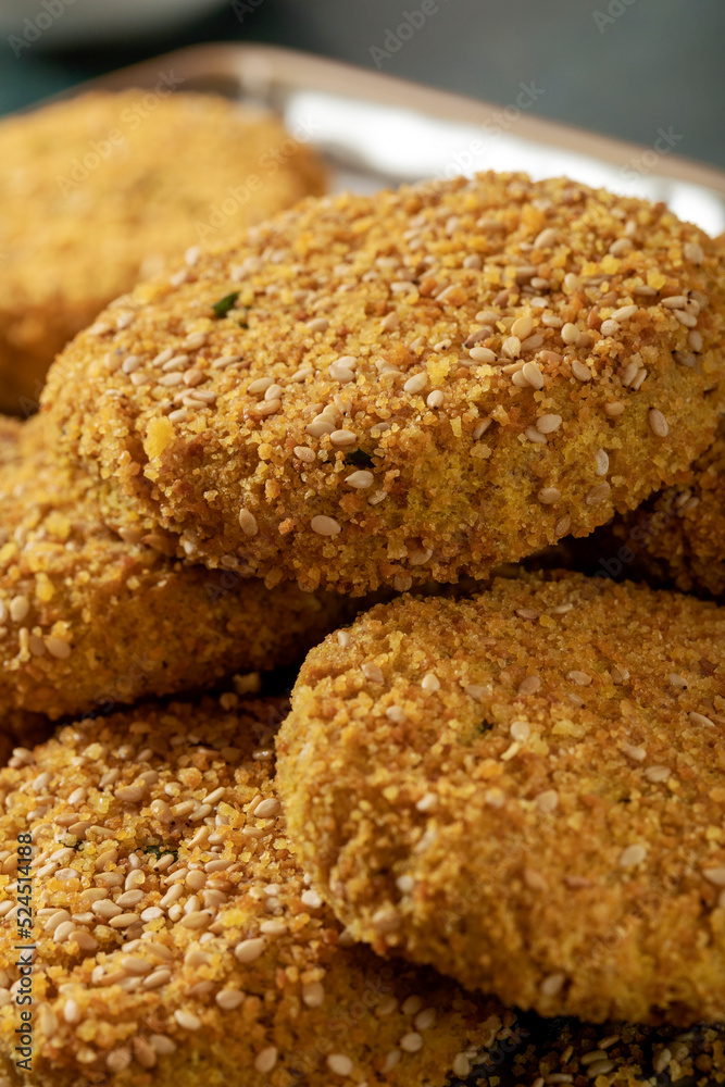 Nuggets (croquettes) with gluten free bread crumb and sesame seeds on a dark background. 