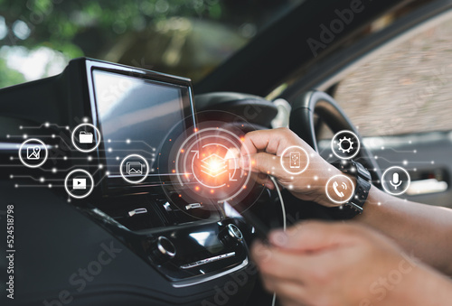 Car business concept and technology on virtual screen,Man hold usb cable connect to car front monitor to transfer data and media from smartphone,icon screen concept of car tecchnology photo