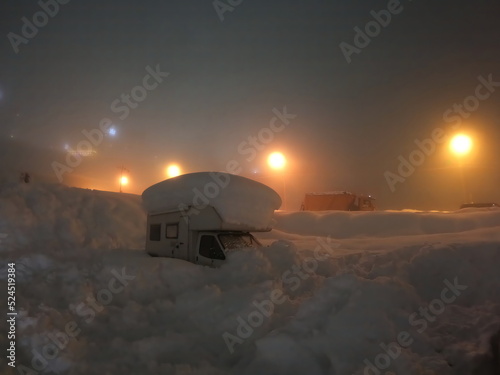Motor home covered in snow. A recreational vehicle camper in snowdrift. Car caravan trailer in a snowdrift. Snowy motorhome. Car caravan trailer covered with snow. Blurred image