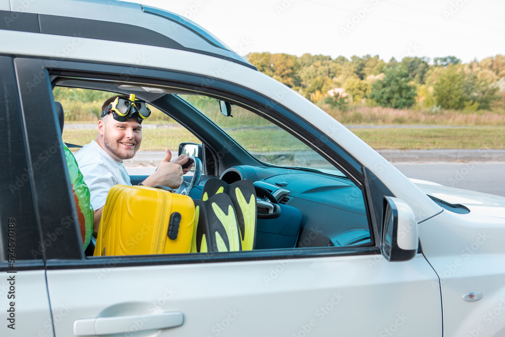 Naklejka premium sea vacation car travel concept man in scuba mask driving car full of bags