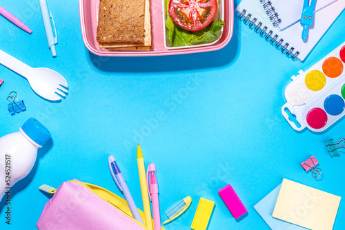 Back to school flatlay background. Pink pencil case with various school stationery on high-colored bright background