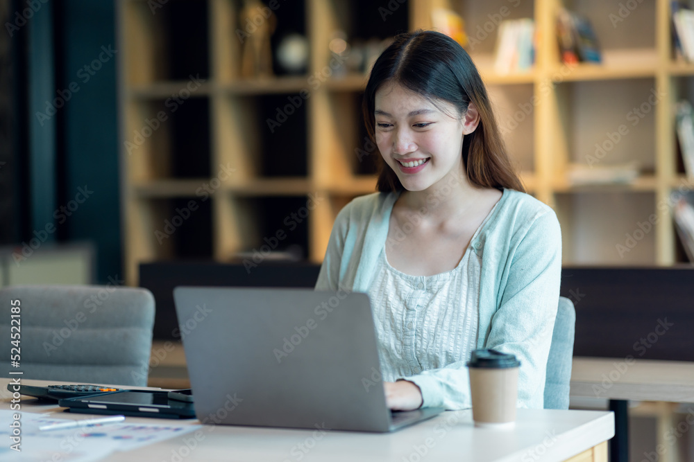 Young Business Asian woman sitting at a desk with a laptop and working in the home office or her workplace, accountant tax contract report analysis document data Audit concept.