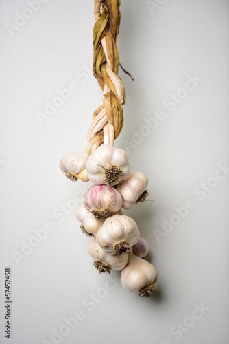Garlic braids hanging up on a neutral kitchen wall