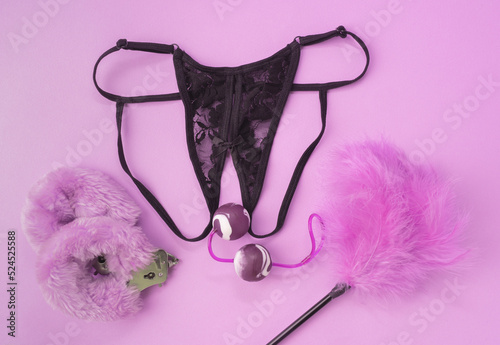 Different adult sex toys with black underwear. Vaginal balls, handcuffs, erotic feathers, black sexy underwear