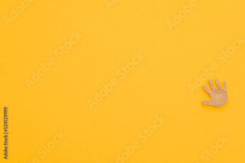 Wooden figures in the form hand on a yellow background
