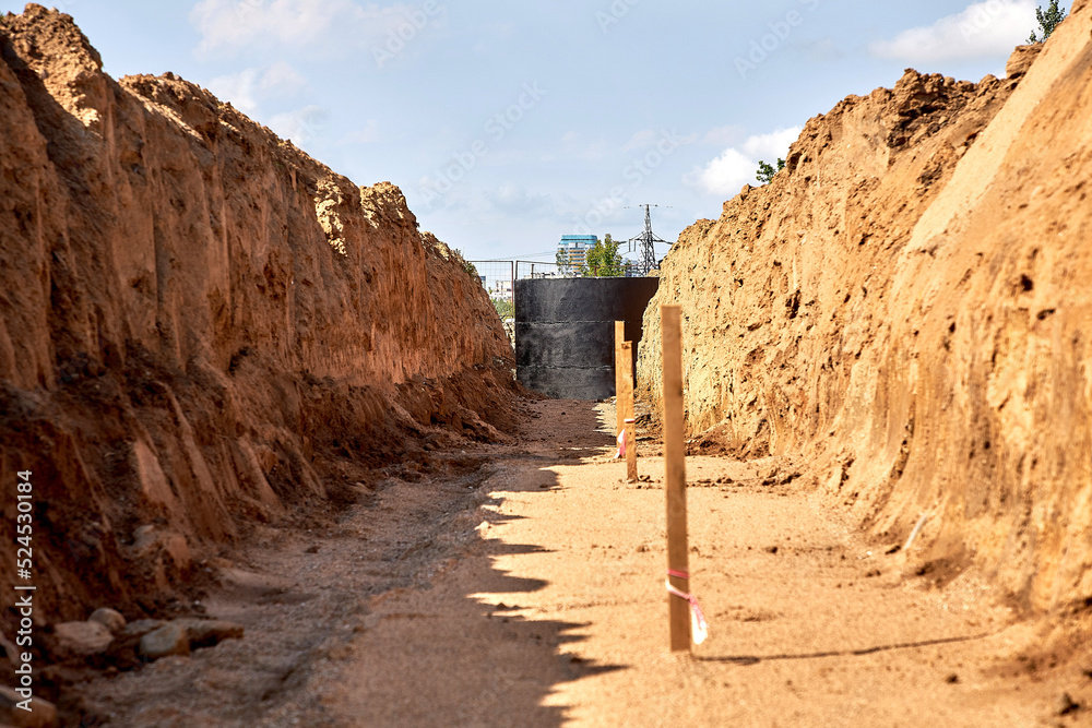The prepared trench was prepared for laying water pipes, with wooden