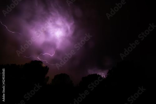 night sky with thunderstorm, lightning and thunder in purple colors