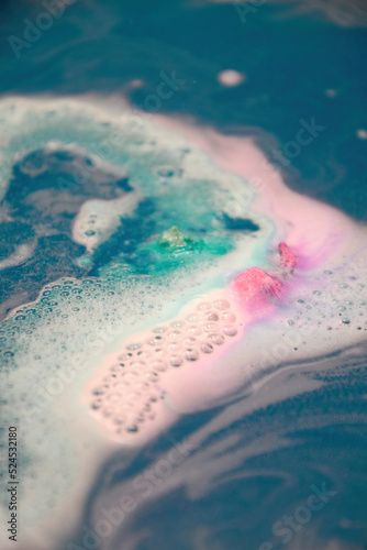 Colorful foam and bubbles in the bath blue water. Abstract backgrounds