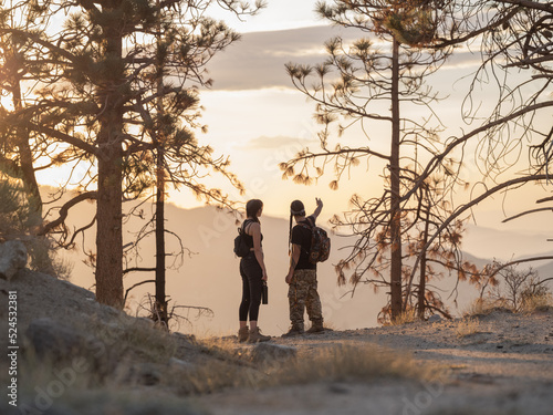 Back horizontal view of Indigenous friends hiking in the forest 