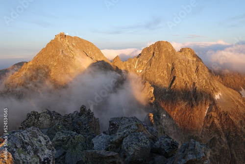 Łomnica oraz Durne Szczyty podczas złotej godziny o wschodzie Słońca widziane z Kieżmarskiego Szczytu w Tatrach Słowackich.