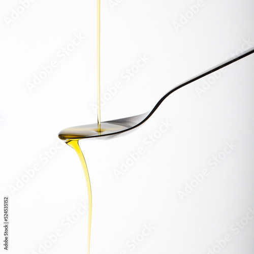 olive oil pouring on a kitchen spoon