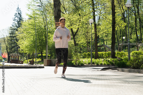 Brunette runner woman runs in the park jogging, concept of training exercise