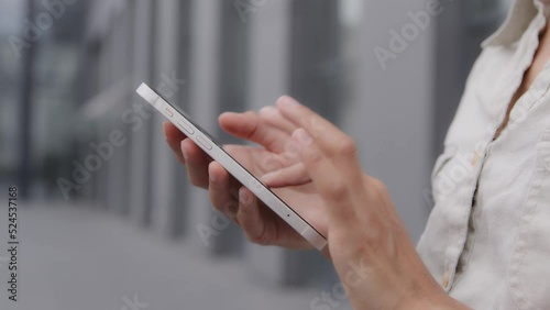 Close-up females hands holding phone. Fingers dialing number on smartphone screen. Unrecognizable woman using mobile application to search for information network calls taxi chatting outdoors in city