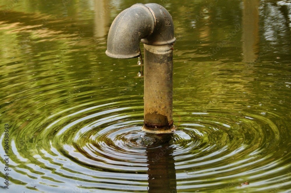 Tubería goteando en un estanque.