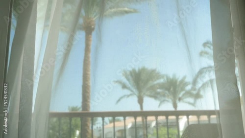 Wallpaper Mural Transparent curtain in balcony with wicker chairs and table and a green tropical background with palm trees, luxury vacation Torontodigital.ca