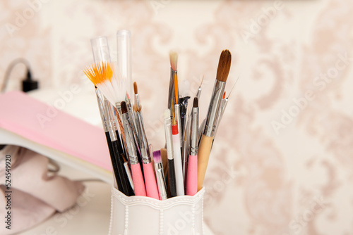 Paint brushes of various colors, sizes and textures in a white container