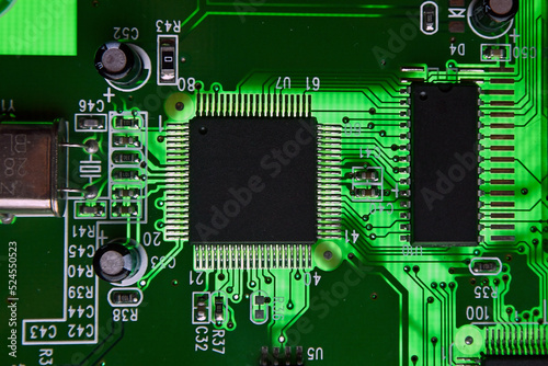 Close-up of electronic circuit board PCB with components: microchip, processor, integrated circuits, capacitors, resistances and electronic connections are noted. macro photography. photo