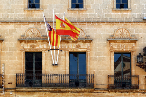 Ciutadella, Menorca (Minorca), Spain. Menorcan architecture, traditional buildings in the old town. Spanish and Menorcan flags waving in the wind