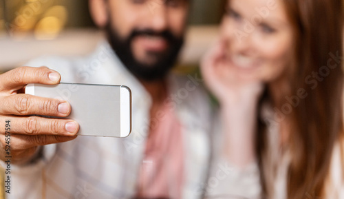 technology and people concept - close up of couple taking selfie with smartphone
