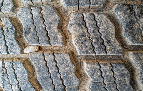 Detail of a section of a tire with a stone stuck between the treads