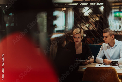 Happy businesspeople smiling cheerfully during a meeting in a coffee shop. Group of successful business professionals working as a team in a multicultural workplace.