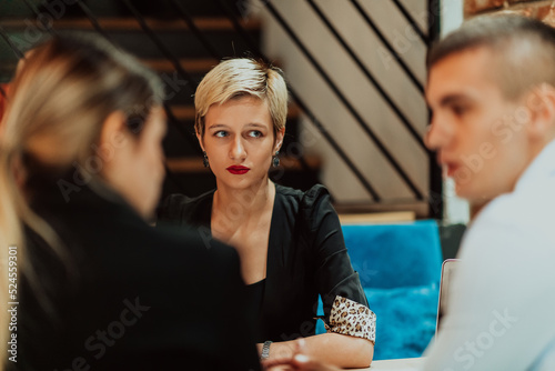 Happy businesspeople smiling cheerfully during a meeting in a coffee shop. Group of successful business professionals working as a team in a multicultural workplace.