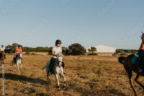 12-year-old girl rides a white pony among friends