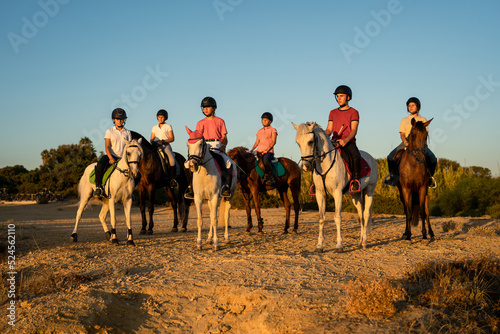 group of 6 young horsemen standing watching the sunset
