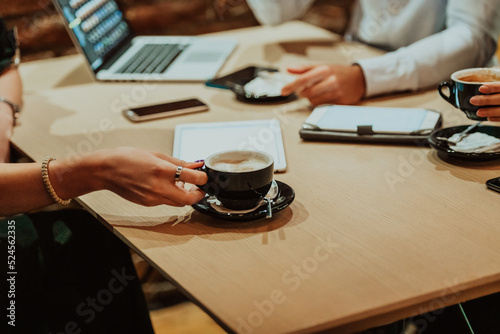 Happy businesspeople smiling cheerfully during a meeting in a coffee shop. Group of successful business professionals working as a team in a multicultural workplace.