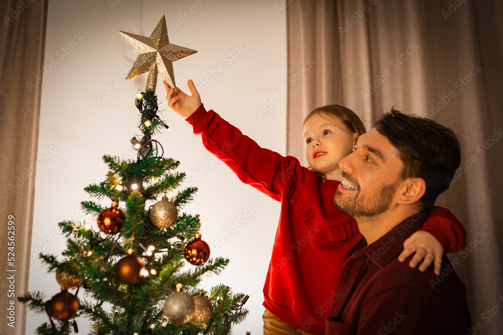family, winter holidays and people concept - happy father and little daughter decorating christmas tree at home family, winter holidays and people concept - happy father and little daughter decorating christmas tree at home