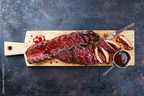 Barbecue pork spare loin ribs St Louis cut with hot honey chili marinade served as top view on a wooden design board with copy space