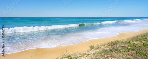 A panoramic view of surf waves breaking and rolling into shore on the sandy beach at Buddina on the Sunshine Coast in Queensland. 