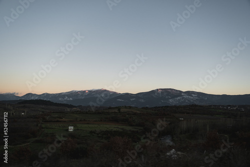 Landscape of Mount Ida with snow and some pine trees on the foreground.