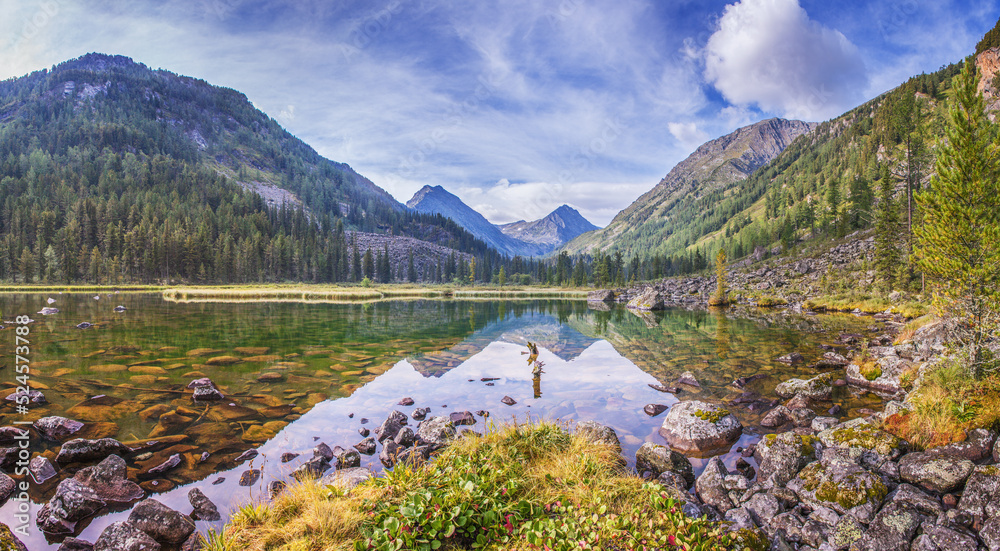 Wild mountain lake, summer landscape, reflection in the water and stones at the bottom