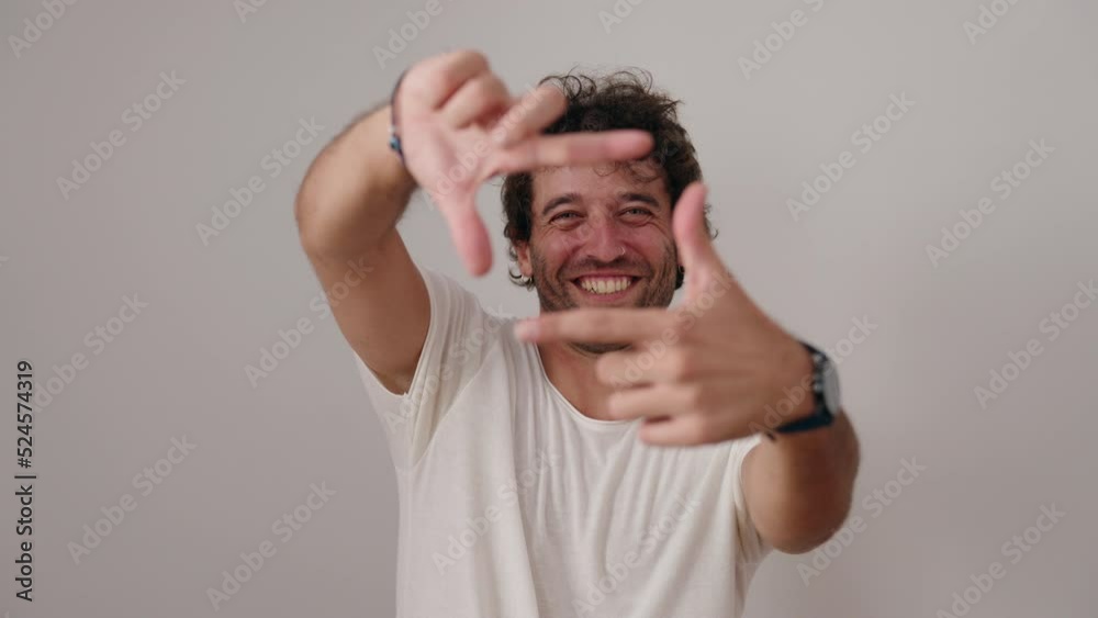 Young hispanic man smiling confident doing photo gesture with hands over isolated white background Young hispanic man smiling confident doing photo gesture with hands over isolated white background