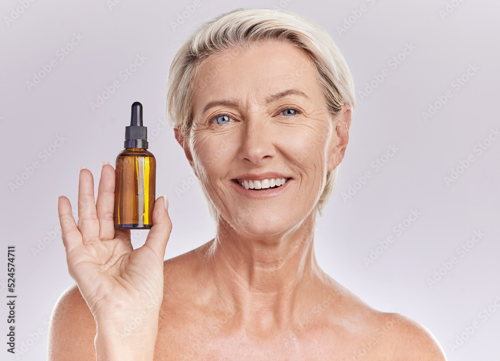 Fototapeta premium Skincare, beauty or makeup product in the hand of a senior woman holding face serum or cosmetic oil in studio on a purple background. Portrait of a female marketing, advertising or endorsing wellness