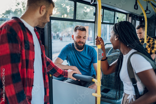 Multiracial group of friends talking while riding in a bus