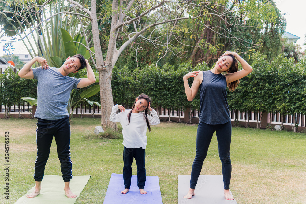 mother, father and child daughter practicing exercising stretching together before yoga mother, father and child daughter practicing exercising stretching together before yoga